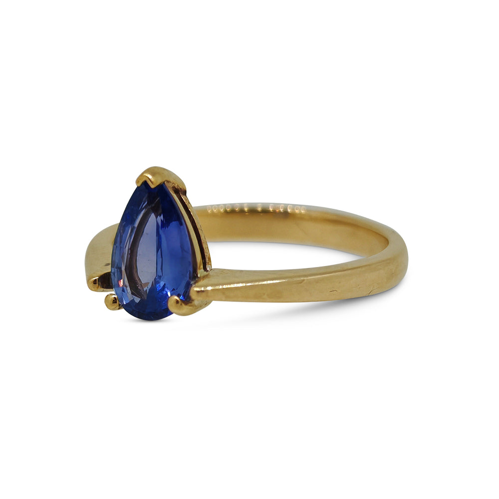 Gold ring with a blue gemstone on a white background